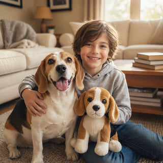 A young boy in a grey hoodie sits on a living room floor, smiling as he holds a real Beagle and a matching Beagle stuffed animal. A perfect Beagle Gift collection featuring toys, apparel, and home decor for all ages.
